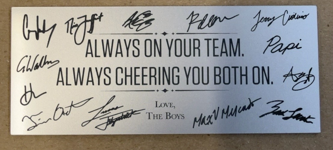 Close-up of the custom nameplate with thirteen hand-extracted signatures surrounding the message: Always on your team. Always cheering you both on. Love, The Boys.